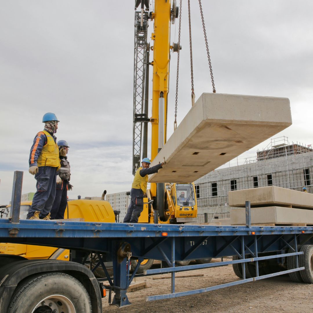 crane lowering blocks onto flatbed trailer
